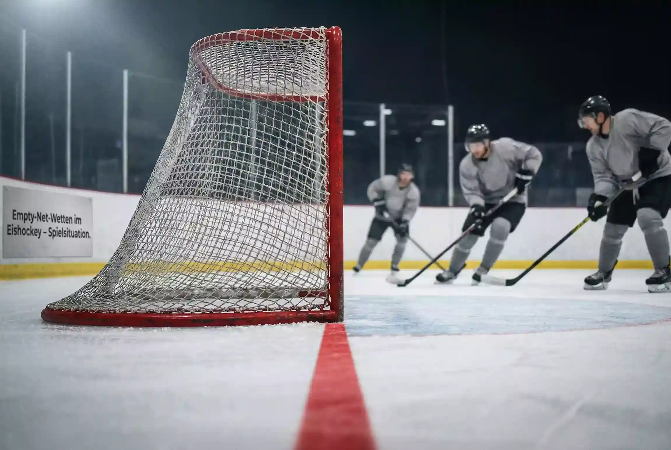 Leeres Eishockeytor mit Spielern im Hintergrund während der Schlussphase